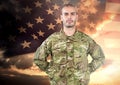 Proud soldier standing on american flag background Royalty Free Stock Photo