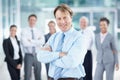 Proud of the success weve achieved. Positive mature business executive smiling while standing with his team behind him - Royalty Free Stock Photo