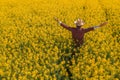 Proud successful oilseed rape farmer in blooming field