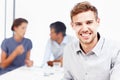 Proud to be a member of this team. Closeup portrait of a smiling young businessman with his colleagues sitting in the Royalty Free Stock Photo