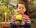 Proud young gardener with a primrose plant.