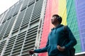 A proud young man looks to the horizon in the background of lgbt flag