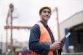 Proud young worker in protective work wear in a shipping yard