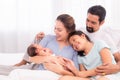 Proudly Asian man hug wife and 2 kids with love, care, protection, adorable daughter lie down on father`s bosom or chest looking Royalty Free Stock Photo