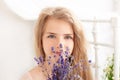 Provence. A close-up portrait of a pensive blonde little girl holding a fragrant bouquet of lavender by her face. The concept of c