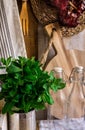 Provence rustic kitchen interior, wood cutting board, utensils, glass bottles, fresh herbs, linen towel on white background Royalty Free Stock Photo