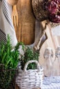 Provence style kitchen interior, white wooden wall, cutting board, utensils, rattan coaster, linen towel, fresh garden herbs