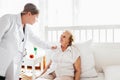 Providing care for elderly. Doctor visiting elderly patient at home. Royalty Free Stock Photo