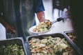 Providing free food to the poor Volunteers scooping out food to give charity to those who are hungry Royalty Free Stock Photo