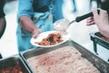 Providing free food to the poor : Volunteers scooping out food to give charity to those who are hungry Royalty Free Stock Photo