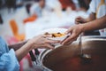 Providing free food to the poor : Volunteers scooping out food to give charity to those who are hungry Royalty Free Stock Photo