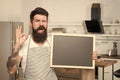 Providing training course. Bearded cook with ok sign holding blackboard in training school. Hipster man giving training