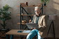 A provincial mature boss. Successful senior man with laptop in hands at workplace in office. Retired work Royalty Free Stock Photo