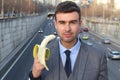 Provocative businessman eating a banana Royalty Free Stock Photo