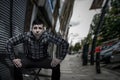 Provocative self-confident man sitting at the street in ready to stand up and fight pose