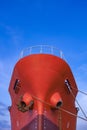 Red Oil Tanker moored at port with mooring rope against blue sky background in vertical frame Royalty Free Stock Photo