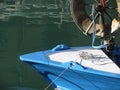 Prow of a wooden fishing boat with trawl winch on the deck . The fishing boat is moored in the harbor . Tuscany, Italy