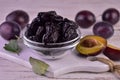 Prune in a glass bowl and fresh plums.Close-up.