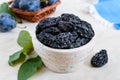 Prunes in a clay bowl and fresh plums, leaves Royalty Free Stock Photo