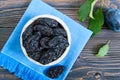 Prunes in a clay bowl and fresh plums, leaves on a wooden table. Royalty Free Stock Photo