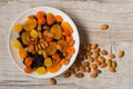 Prunes, dried apricots, dried mandarins and almonds in a bowl on a light wooden background Royalty Free Stock Photo