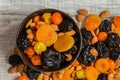 Prunes, dried apricots, dried mandarins and almonds in a bowl on a light wooden background Royalty Free Stock Photo