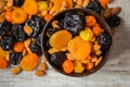 Prunes, dried apricots, dried mandarins and almonds in a bowl on a light wooden background Royalty Free Stock Photo