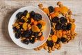 Prunes, dried apricots, dried mandarins and almonds in a bowl on a light wooden background Royalty Free Stock Photo