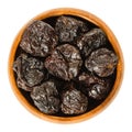 Prunes, dried plums in wooden bowl over white Royalty Free Stock Photo