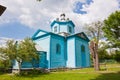 Prybuzke, Ukraine: view of a churchyard with Assumption of the Mother of God russian Orthodox church, bells attached to a cut tree