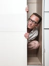 Prying man hiding inside white wardrobe Royalty Free Stock Photo