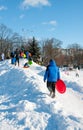 Pryluky, Chernihiv, Ukraine - 02/15/2021: Children ride with their parents on a snow slide in the city square