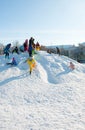 Pryluky, Chernihiv, Ukraine - 02/15/2021: Children ride with their parents on a snow slide in the city square