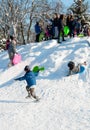 Pryluky, Chernihiv, Ukraine - 02/15/2021: Children ride with their parents on a snow slide in the city square