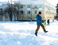 Pryluky, Chernihiv, Ukraine - 02/15/2021: Happy cheerful boy jumps on a snow slide