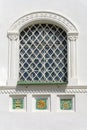 Pskov, a fragment of the facade of the Holy Trinity Cathedral, a window and tile decorations Royalty Free Stock Photo