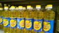 Rows of bottles of sunflower oil for sale on supermarket shelves. Organic food background. Retail industry. Discount. Grocery shop