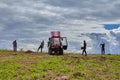 Farmers remove old grass from field with uses farm forks.