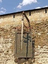 PSKOV, RUSSIA. Coat of arms and sword on the wall of the Pskov Krom Kremlin. Russian text - Whoe comes with a sword will perish