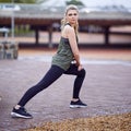 Psyched to run. a young woman stretching her legs before a run.