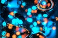 Psychedelic abstract fluid background with flowing big bubbles and bokeh lights of blue, cyan and orange color. mysterious Royalty Free Stock Photo