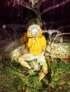 Psychedelic glitch horror skull mask man on abandoned car background