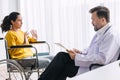 Psychiatrist doctor collect data talk with patient on wheelchair for mental care health problems check followup in hospital clinic Royalty Free Stock Photo