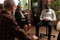 Psychiatrist talking to african american man at group therapy session Royalty Free Stock Photo