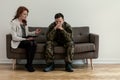 Psychiatrist talking to her angry patient while sitting on a sofa Royalty Free Stock Photo