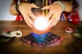 Psychic readings and clairvoyance concept - Crystal ball fortune teller hands and Tarot cards reading divination Royalty Free Stock Photo