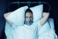 Psycho man with taped mouth lying in bed Royalty Free Stock Photo