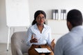 Psychological counseling. Professional female psychotherapist having session with young black guy at office