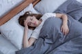 Psychological health care. Sad lady lying alone in bed, suffering from depression or having sleep disorder, top view Royalty Free Stock Photo