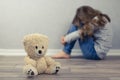 Psychological health concept. A teddy bear and in the background a teenage girl out of focus. Psychological assistance to children